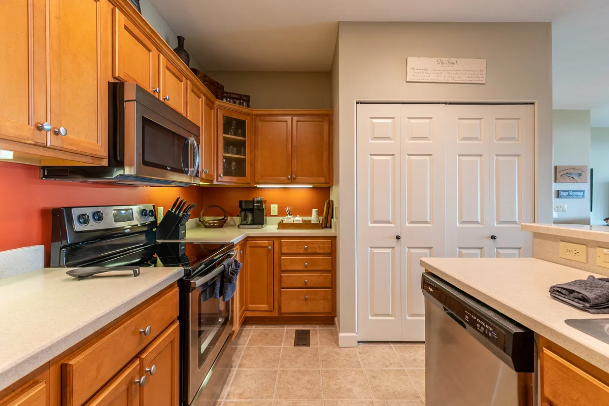 A spacious kitchen scene with prominent appliances, ample wooden cabinetry, and generous countertop space. The layout encourages culinary creativity and socializing, ideal for group cooking or family meals.